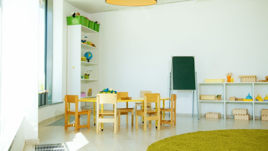 Sala colorida de educação infantil com mesas, cadeiras e materiais pedagógicos.