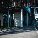 Fachada de uma unidade de saúde contemporânea, com área ajardinada e caminho de acesso.