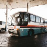 Ônibus colorido parado em uma estação de transporte ao ar livre.