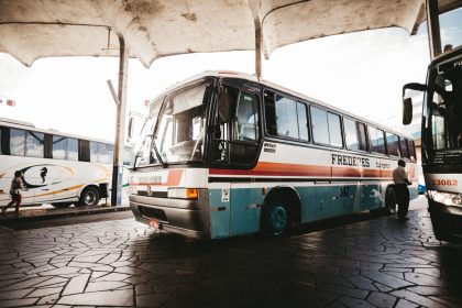 Ônibus colorido parado em uma estação de transporte ao ar livre.