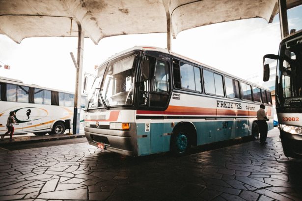 Ônibus colorido parado em uma estação de transporte ao ar livre.