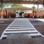Pessoas caminham e aguardam diante da entrada de uma unidade de saúde em Londrina, no Paraná.