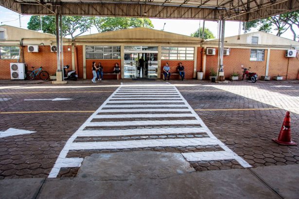 Pessoas caminham e aguardam diante da entrada de uma unidade de saúde em Londrina, no Paraná.