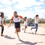 Grupo de crianças brinca ao ar livre em um parque público em Brasília.