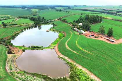 Vista aérea de áreas verdes extensas com campos e dois pequenos lagos.