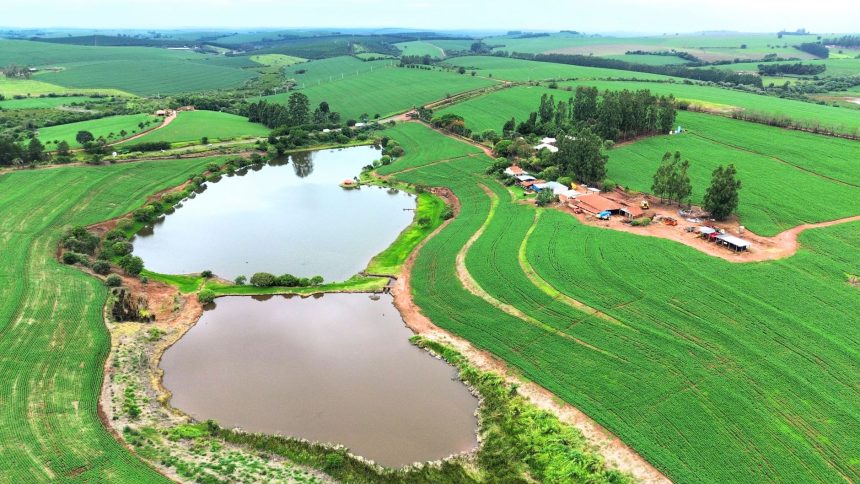Vista aérea de áreas verdes extensas com campos e dois pequenos lagos.